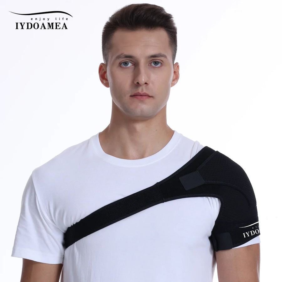 Man wearing black adjustable shoulder support brace over white shirt for pain relief